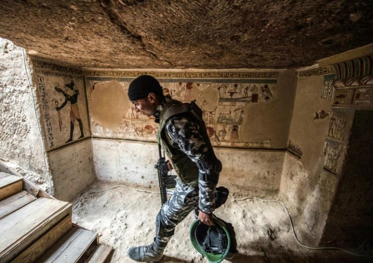 Un membre des forces de sécurité égyptiennes à l'entrée d'une tombe datant de 2.000 ans dévoilée le 5 avril 2019 à Akhmim  © AFP Khaled DESOUKI