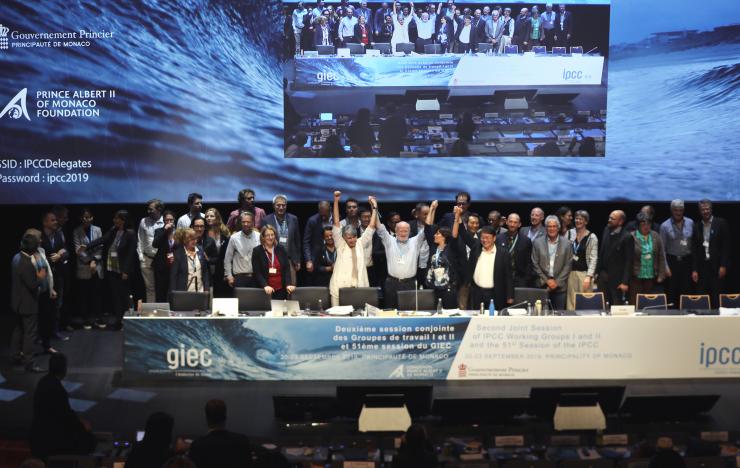 Valérie Masson-Delmotte au centre, les bras levés avec les autres co-présidents des groupes 1 et 2, célébrant l'adoption du rapport spécial sur les océans et la cryosphère, à Monaco en septembre 2019. 
