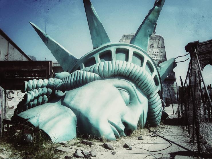 illustration post apocalyptique avec la tête de la statue de la liberté au sol.