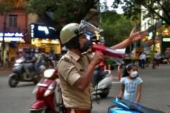 Un policier appelle les passants à se disperser dans un quartier commercial à Bangalore, le 14 juillet 2020, où des zones de reconfinement sont décrétées © AFP Manjunath Kiran