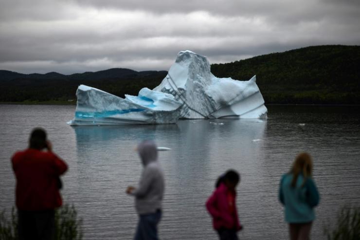 Des touristes regardent un iceberg flotter le 3 juillet 2019 près de King's Point, sur l'île de Terre-Neuve, Canada 