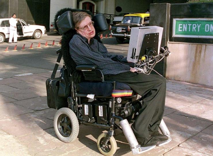 L'astrophysicien Stephen Hawking se déplace en fauteuil roulant fait sur mesure dans une rue de Bombay en janvier 2001 en Inde