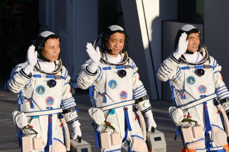 Les astronautes chinois Nie Haisheng (C), Liu Boming (D) et Tang Hongbo avant leur départ vers la station spatiale chinoise, le 17 juin 2021 © AFP Greg Baker