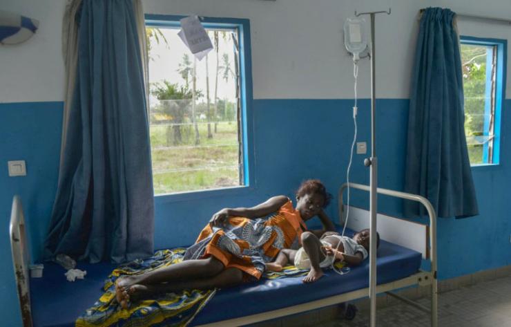 Une femme près d'un enfant ayant contracté le paludisme à Jacqueville, en Côte d'Ivoire, le 19 avril 2019 © AFP Sia KAMBOU