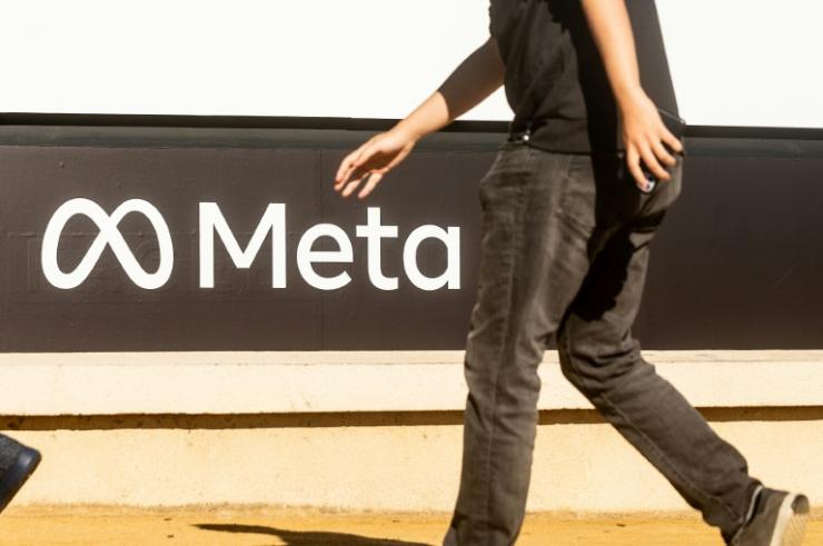 Une personne passe devant le logo de Meta, le nouveau nom de Facebook, devant le siège de la compagnie américaine le 28 octobre 2021 à Menlo Park, en Californie © AFP Noah Berger