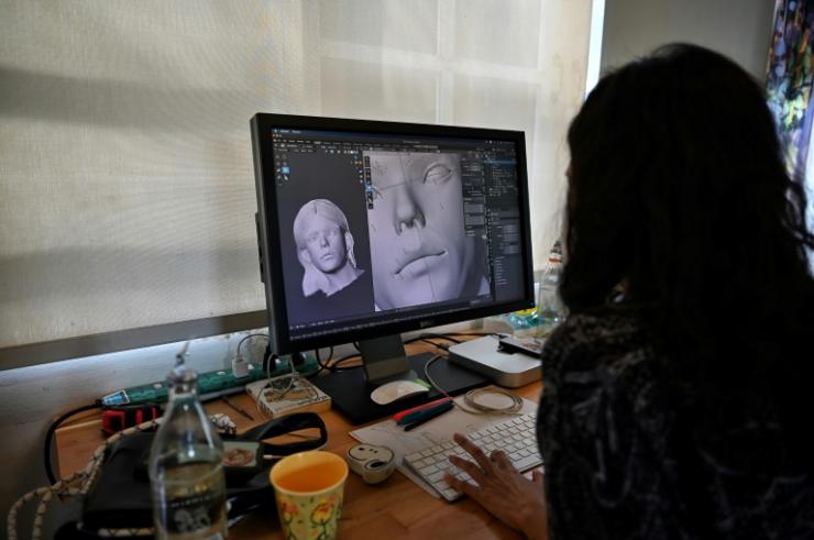 Une graphiste numérique travaille le visage de l'influenceur numérique Bangkok Naughty Boo, le 14 octobre 2021 à Bangkok © AFP Lillian Suwanrumpha
