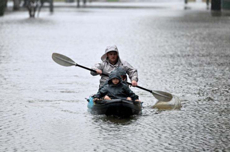 Des habitants se déplacent en kayak après des pluies torrentielles à Windsor, près de Sydney, en Australie, le 4 juillet 2022 © AFP Saeed Khan