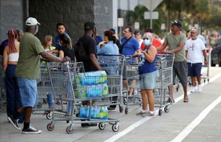 Des personnes font la queue devant un supermarché pour faire des provisions d'eau et de nourriture à l'approche de la tempête tropical Ian, le 25 septembre 2022 à Kissimmee, en Floride © AFP Gregg Newton