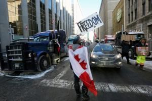 Un manifestant brandit une pancarte marquée "Liberté" alors que des routiers continuent de manifester contre les restrictions anti-Covid, à Ottawa le 5 février 2022 © AFP Dave Chan